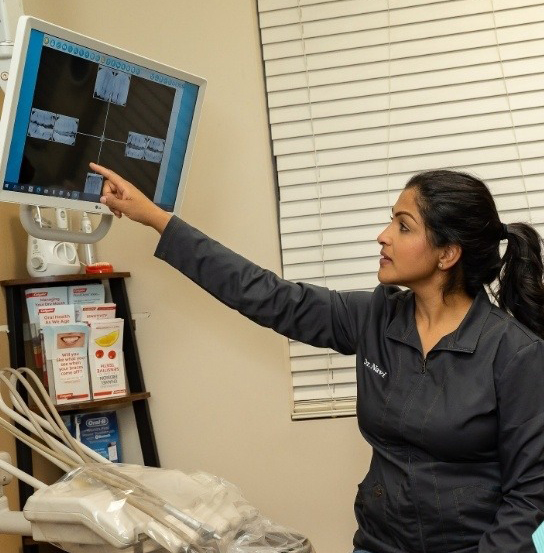 Dentist pointing to screen showing digital images of teeth