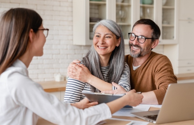 Woman talking to smiling couple across table